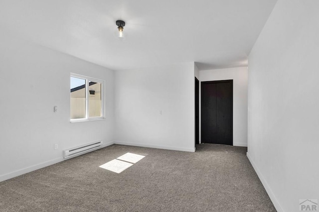 unfurnished room with carpet floors, baseboards, and a baseboard heating unit