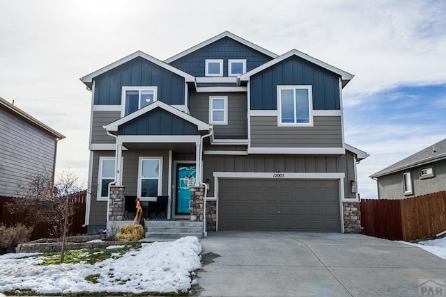 craftsman inspired home with board and batten siding, driveway, a garage, and fence