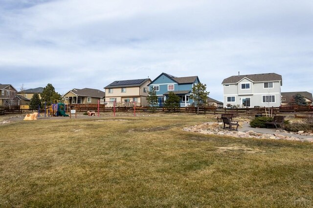 view of yard featuring a residential view, fence, and a playground