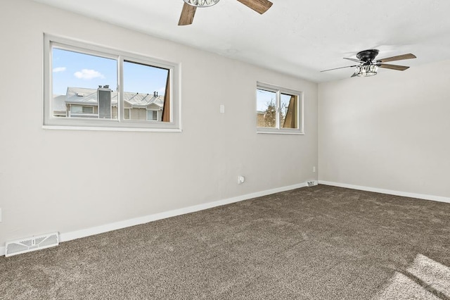 carpeted spare room with ceiling fan, visible vents, and baseboards