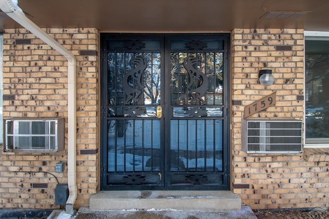 property entrance with french doors, brick siding, and visible vents