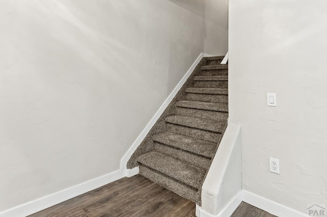 stairway with wood finished floors and baseboards