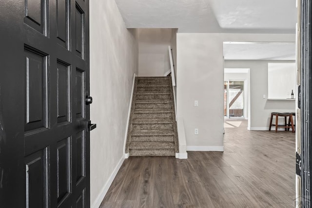 interior space featuring stairs, baseboards, and dark wood-type flooring