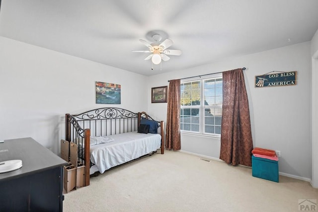 carpeted bedroom featuring a ceiling fan, visible vents, and baseboards