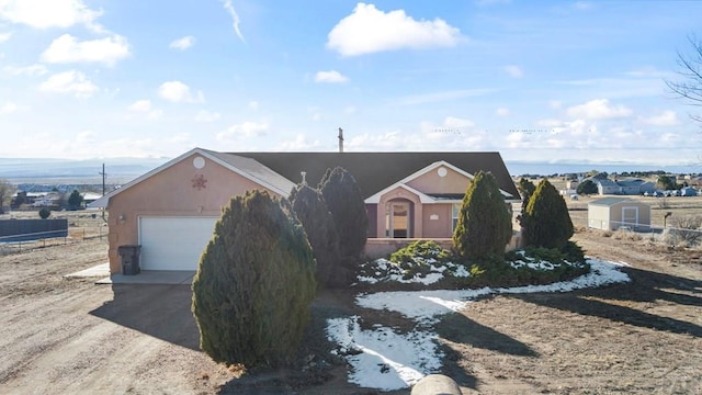 view of front of property with a garage, driveway, and stucco siding