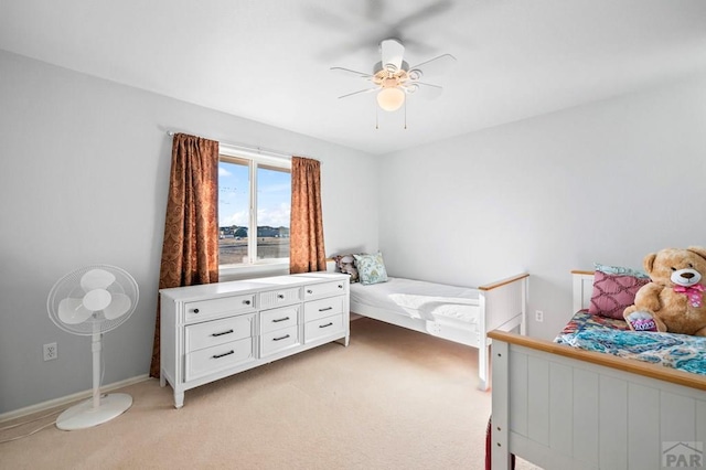 bedroom featuring light carpet, ceiling fan, and baseboards