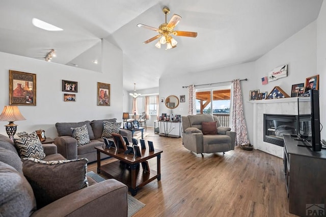 living area featuring high vaulted ceiling, ceiling fan, a premium fireplace, and wood finished floors