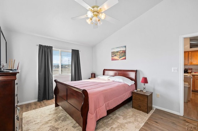 bedroom with lofted ceiling, light wood finished floors, a ceiling fan, and baseboards