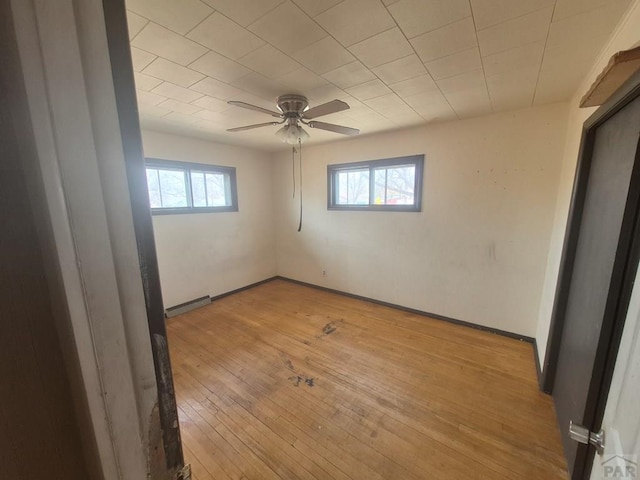 unfurnished room with baseboards, a ceiling fan, visible vents, and light wood-style flooring