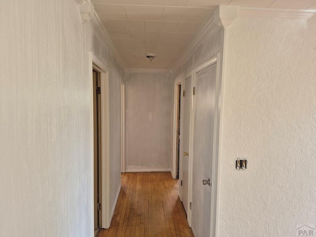 hall with hardwood / wood-style floors and ornamental molding