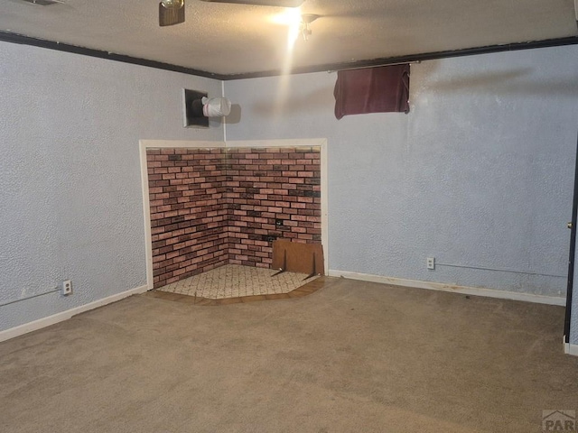 finished below grade area featuring a textured wall, baseboards, and carpet floors