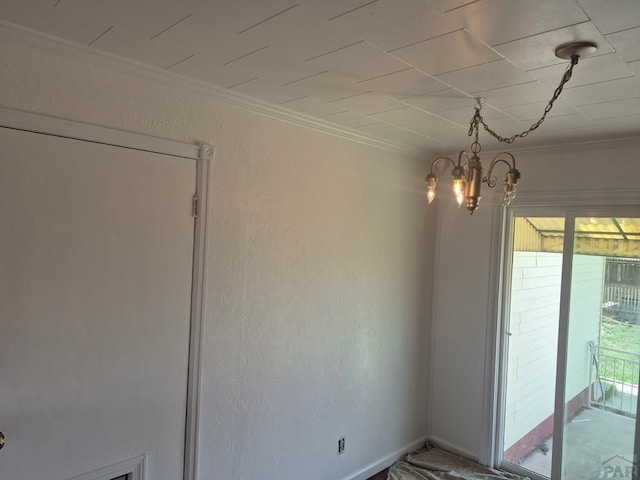spare room with ornamental molding and a notable chandelier