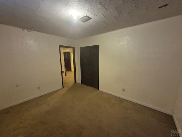 spare room featuring carpet flooring and baseboards