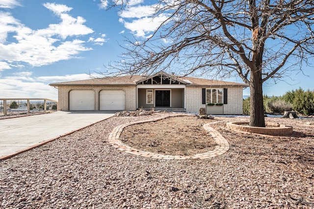 ranch-style home featuring brick siding, driveway, and an attached garage