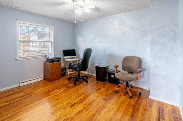 1329 Alexander Cir, Pueblo, CO 81001 - office space with a baseboard radiator, light wood-style flooring, ceiling fan, and a textured ceiling
