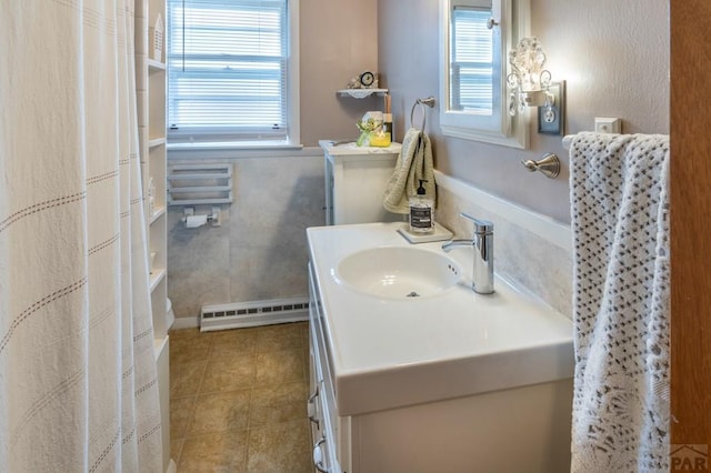 1329 Alexander Cir, Pueblo, CO 81001 - bathroom featuring a baseboard radiator, vanity, plenty of natural light, and tile patterned flooring