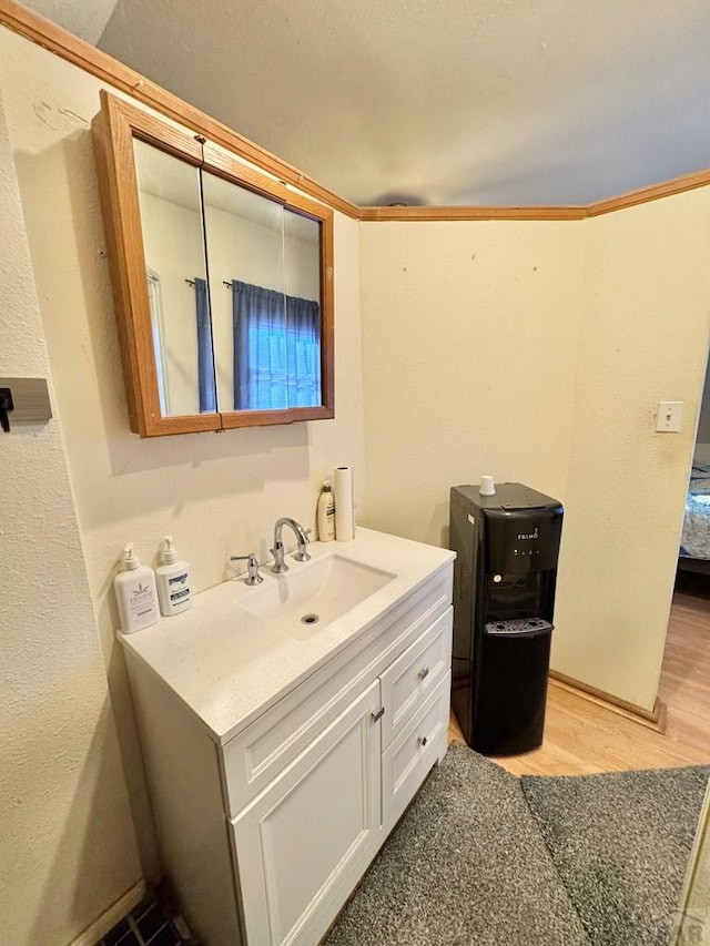 ensuite bathroom with wood finished floors, connected bathroom, and vanity