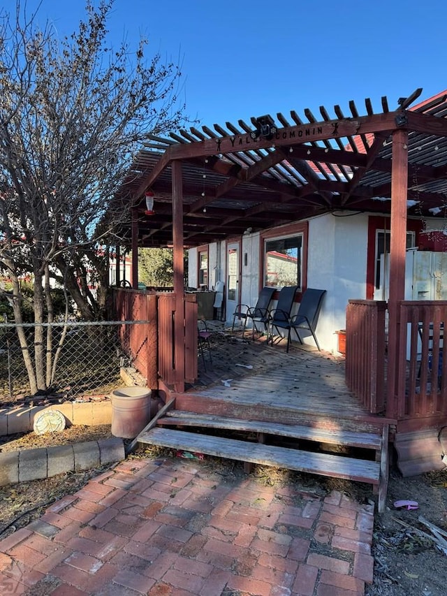 wooden deck featuring fence and a pergola