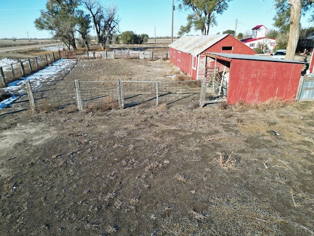 view of yard featuring a rural view, fence, and an outdoor structure