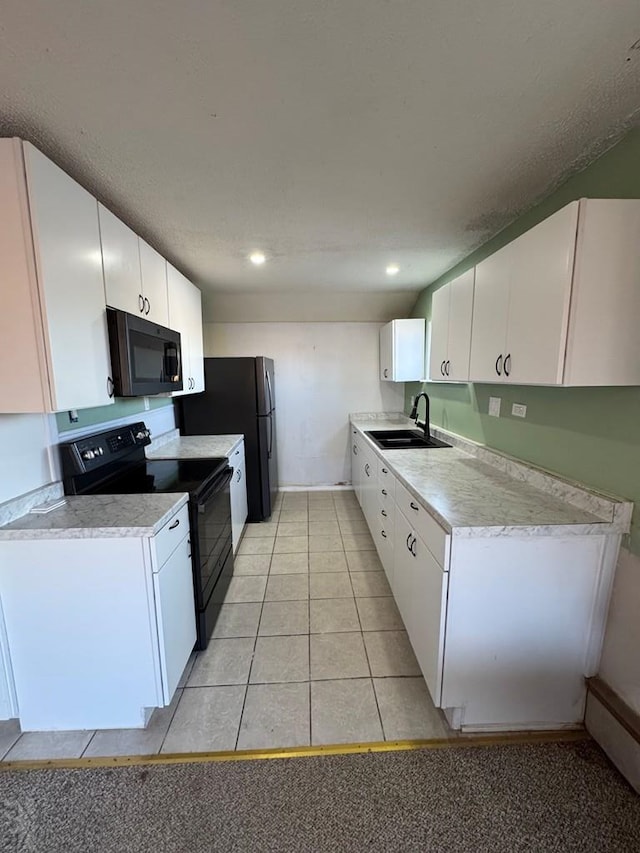 kitchen featuring black appliances, white cabinetry, light countertops, and a sink