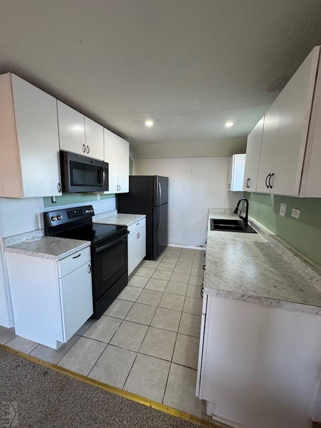 kitchen featuring black appliances, light countertops, a sink, and white cabinetry