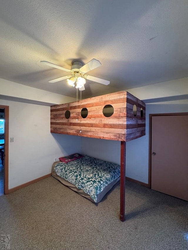 unfurnished bedroom featuring a textured ceiling, carpet, a ceiling fan, and baseboards