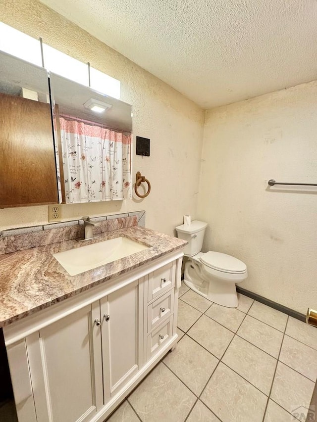 bathroom with a textured wall, toilet, tile patterned flooring, a textured ceiling, and vanity