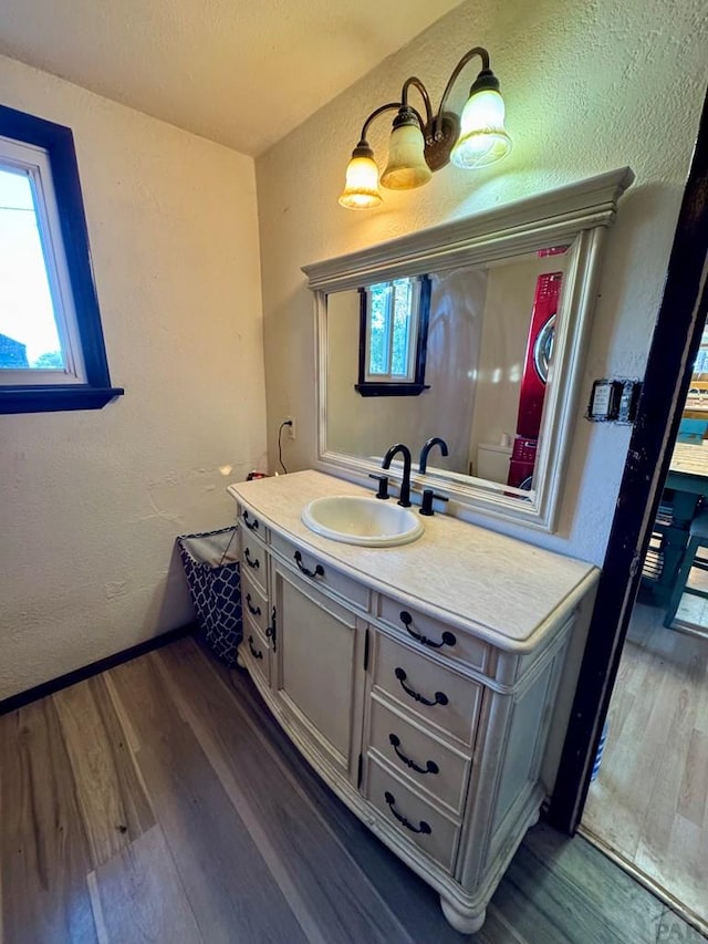 bathroom with a textured wall, wood finished floors, and vanity