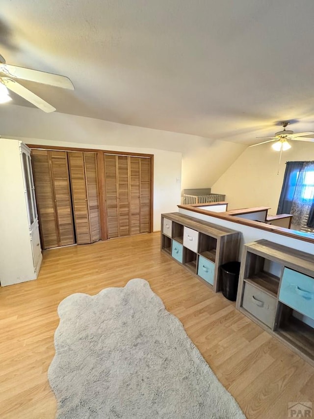 bedroom with vaulted ceiling, light wood-style flooring, and a ceiling fan