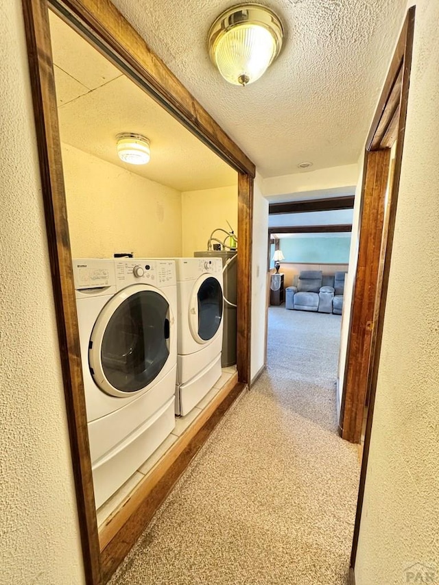 laundry room with laundry area, a textured wall, carpet, a textured ceiling, and washer and dryer