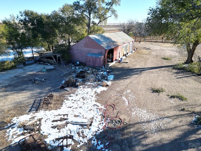 view of side of home with driveway, a pole building, and an outbuilding