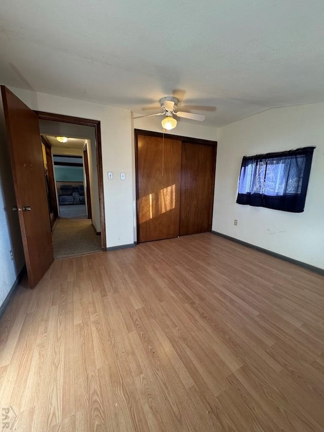 interior space featuring light wood-type flooring, ceiling fan, and baseboards