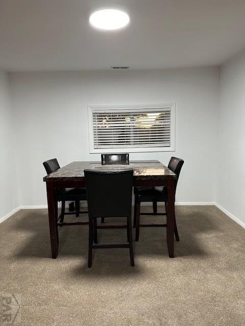 dining room featuring dark colored carpet, visible vents, and baseboards