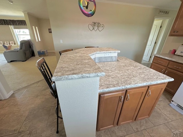 15406 County Rd E.25, Ordway, CO 81063 - kitchen featuring a center island, ornamental molding, light countertops, brown cabinets, and open floor plan