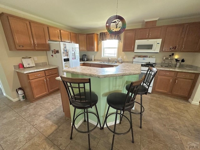 15406 County Rd E.25, Ordway, CO 81063 - kitchen with white appliances, light countertops, a center island, crown molding, and a breakfast bar area