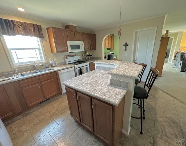 15406 County Rd E.25, Ordway, CO 81063 - kitchen featuring white appliances, a center island, arched walkways, light countertops, and crown molding