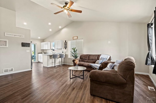 living area featuring vaulted ceiling, ceiling fan, dark wood-style flooring, and visible vents