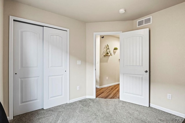 unfurnished bedroom featuring a closet, carpet, visible vents, and baseboards