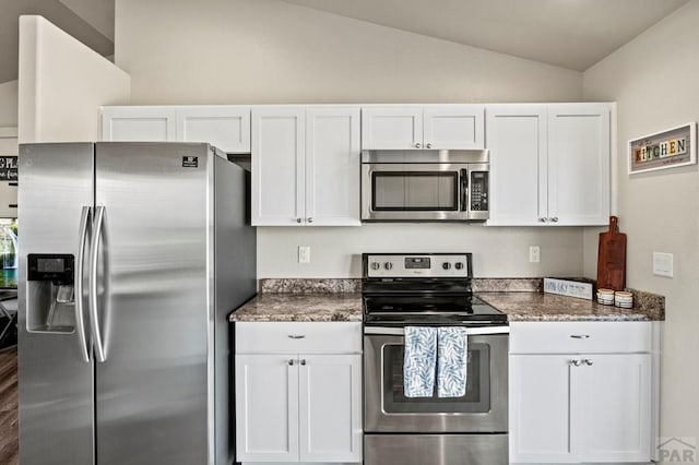 kitchen with white cabinets, stainless steel appliances, and lofted ceiling