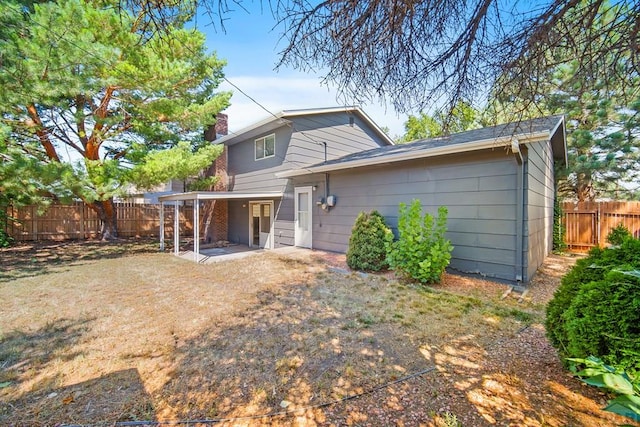 130 Montcalm Dr, Pueblo, CO 81005 - rear view of house with a fenced backyard, a chimney, and a patio area