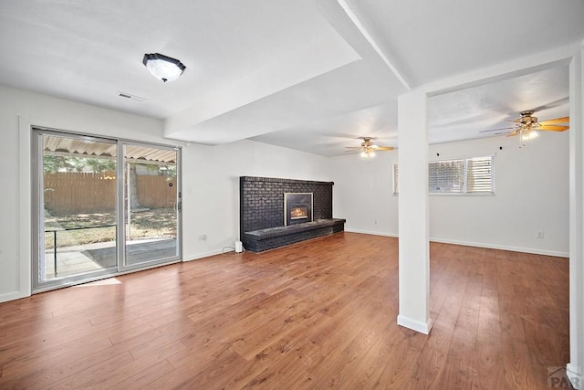 130 Montcalm Dr, Pueblo, CO 81005 - unfurnished living room featuring a ceiling fan, wood finished floors, and a brick fireplace