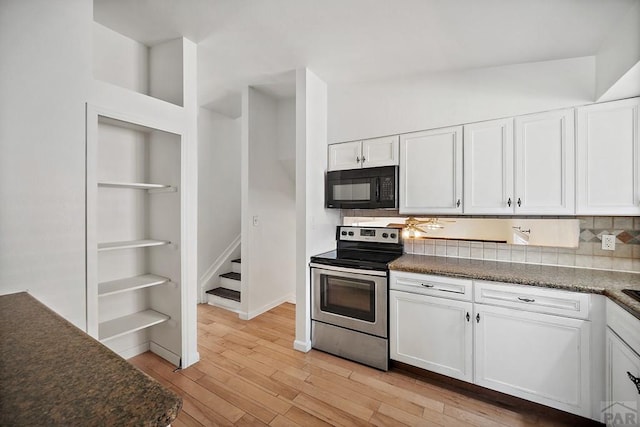 130 Montcalm Dr, Pueblo, CO 81005 - kitchen with black microwave, stainless steel electric stove, white cabinetry, light wood-style floors, and tasteful backsplash