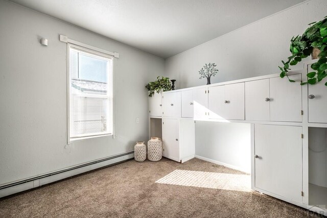 unfurnished bedroom with a baseboard radiator and light carpet