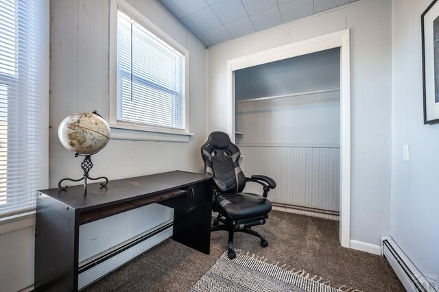 half bathroom with toilet, a baseboard heating unit, wood finished floors, and visible vents