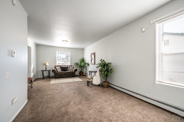 dining area featuring dark wood-style floors, washer / clothes dryer, a baseboard radiator, and baseboards