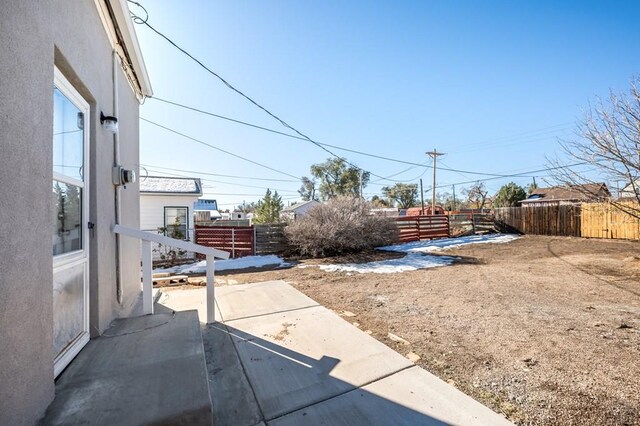 rear view of property featuring a patio, fence, and stucco siding