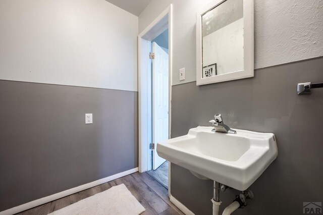 spare room featuring a baseboard heating unit, dark colored carpet, a textured ceiling, and a textured wall