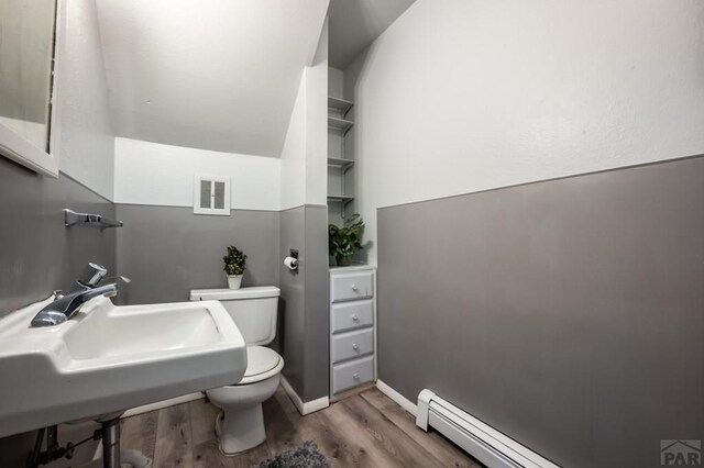 bathroom featuring a baseboard radiator, visible vents, toilet, and wood finished floors