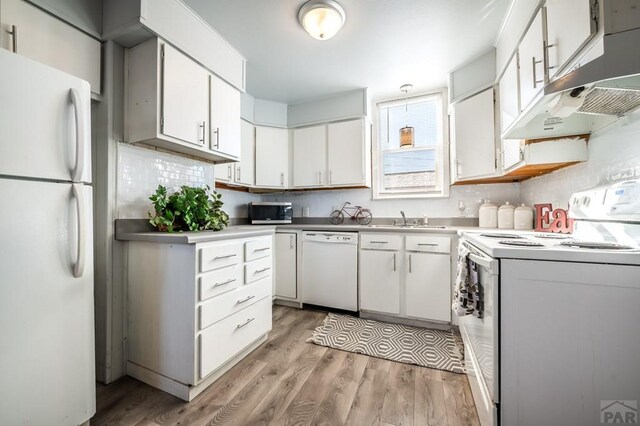 kitchen featuring light countertops, white appliances, white cabinetry, and under cabinet range hood