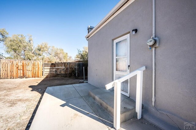 view of home's exterior with fence, a patio, and stucco siding